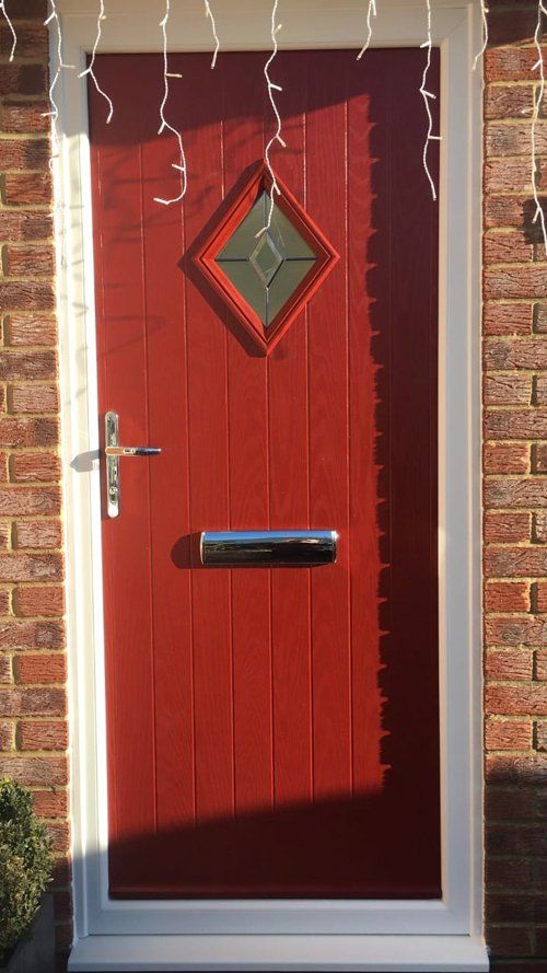 A red composite door with diamond shaped window