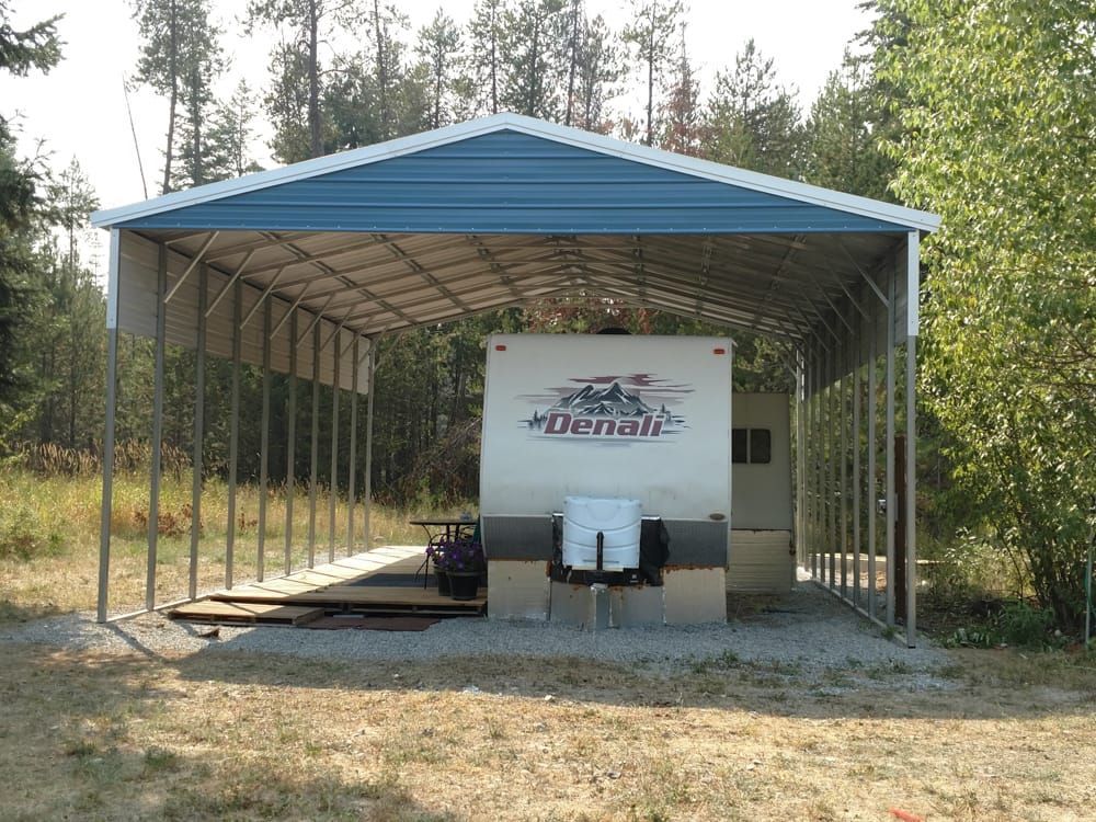 A trailer is parked under a blue and white building.