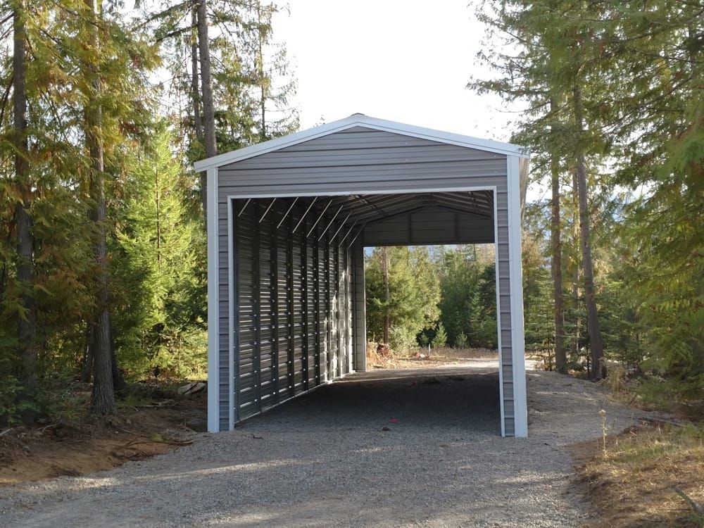 A carport in the middle of a gravel road