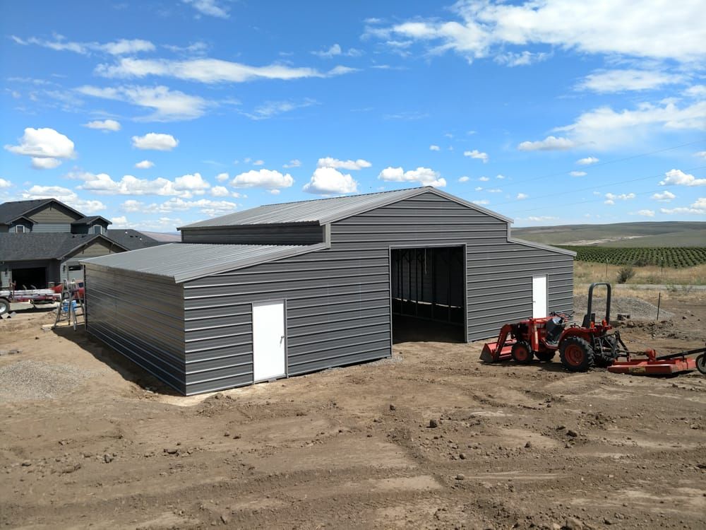 A tractor is parked in front of a metal building.