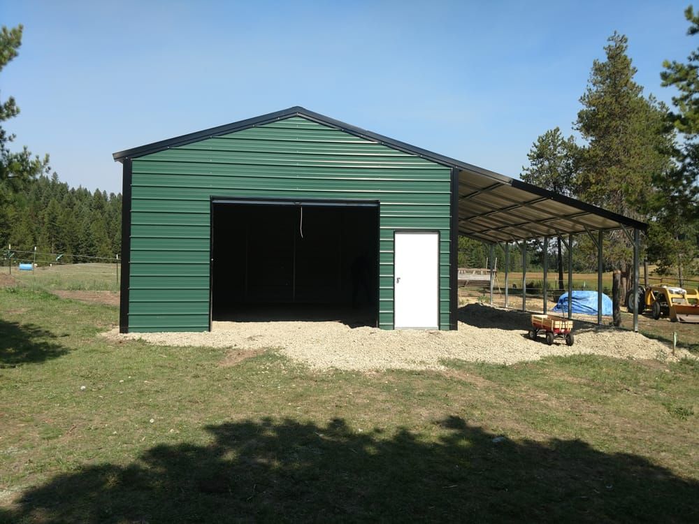 A green metal building with a white door
