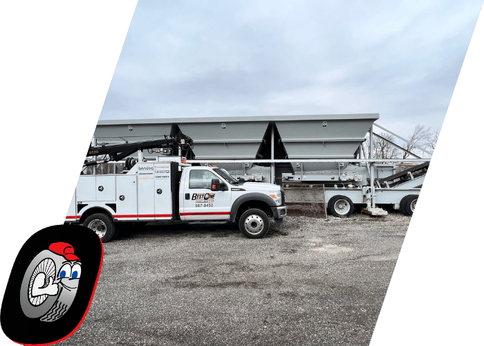 Utility service truck parked beside heavy industrial equipment at a commercial work site.