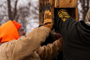 Volunteers put up a wood duck nest box.