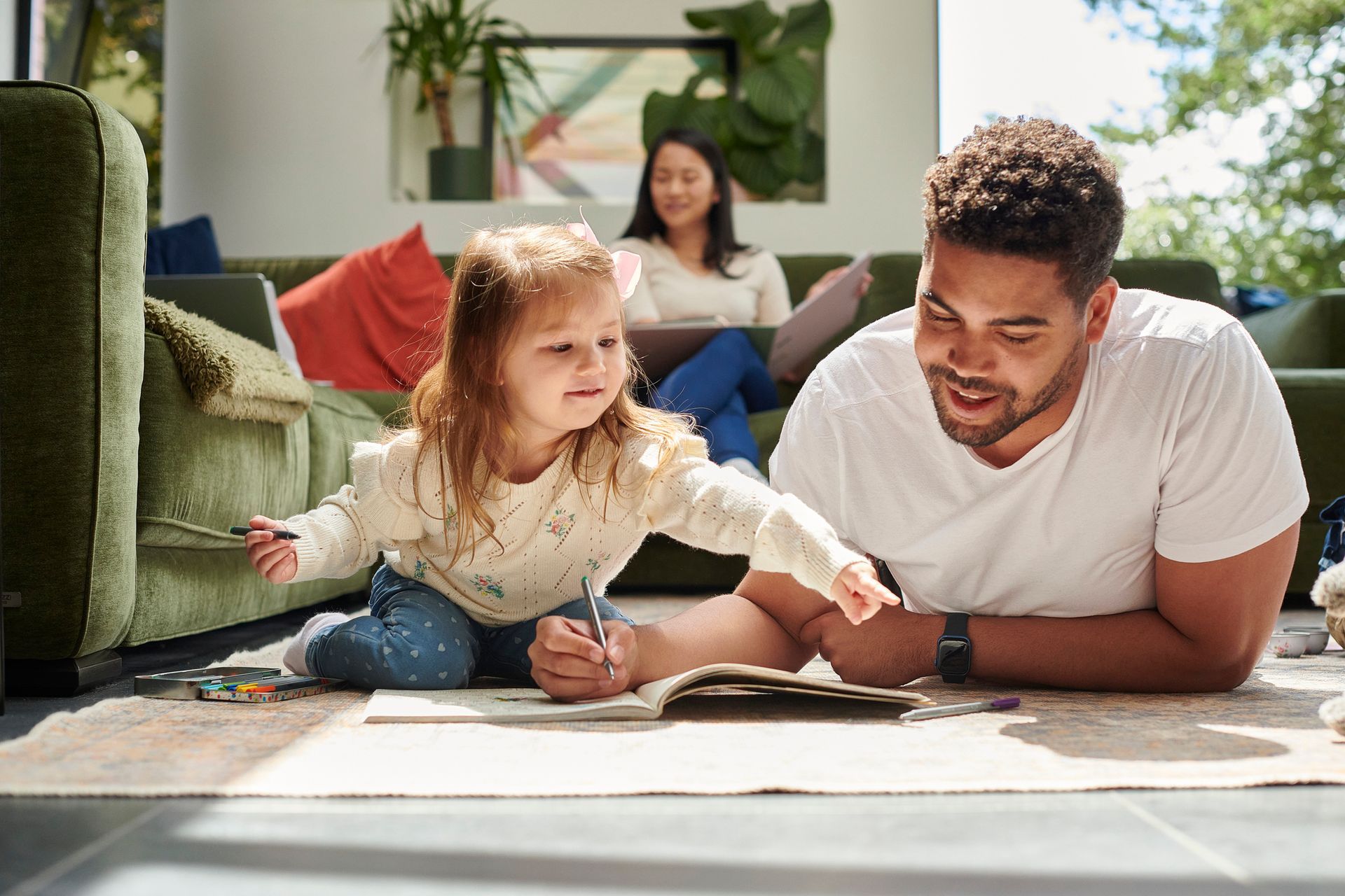 A family of three bonding in the living room of their home.
