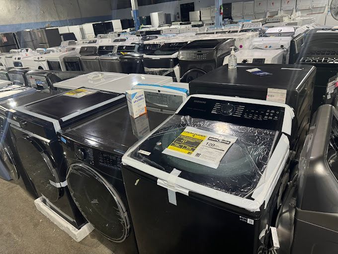 A warehouse filled with lots of washing machines and dryers.
