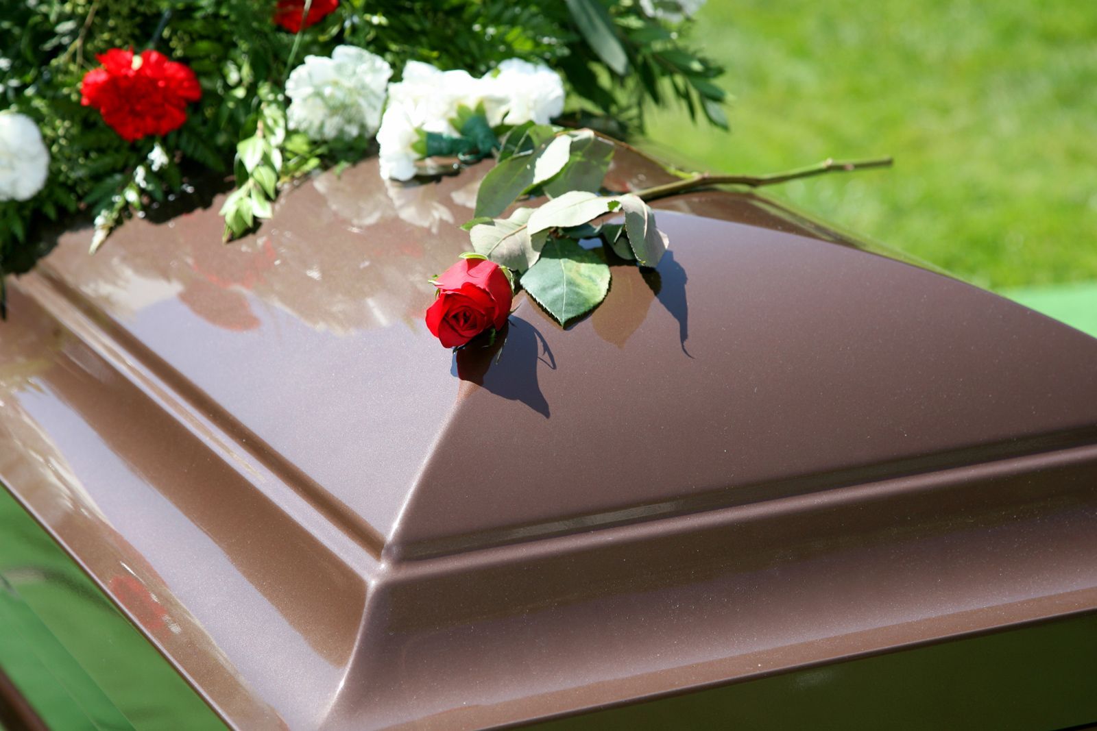 Brown Casket With Flowers — Gallup, NM — Silver Creek Mortuary LLC