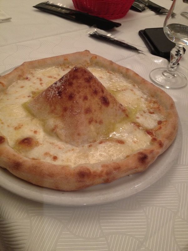 Una pizza con un pezzo di pane sopra, su un piatto su un tavolo.