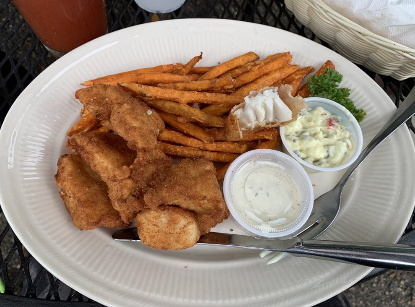 A white plate topped with fried fish and french fries