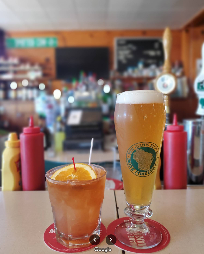 Two glasses of beer are on a table in a restaurant