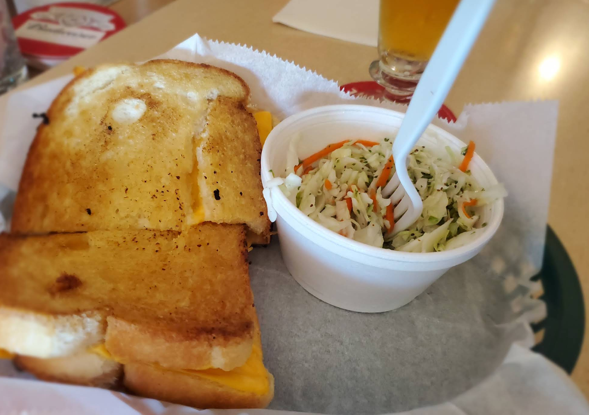 A grilled cheese sandwich next to a bowl of coleslaw