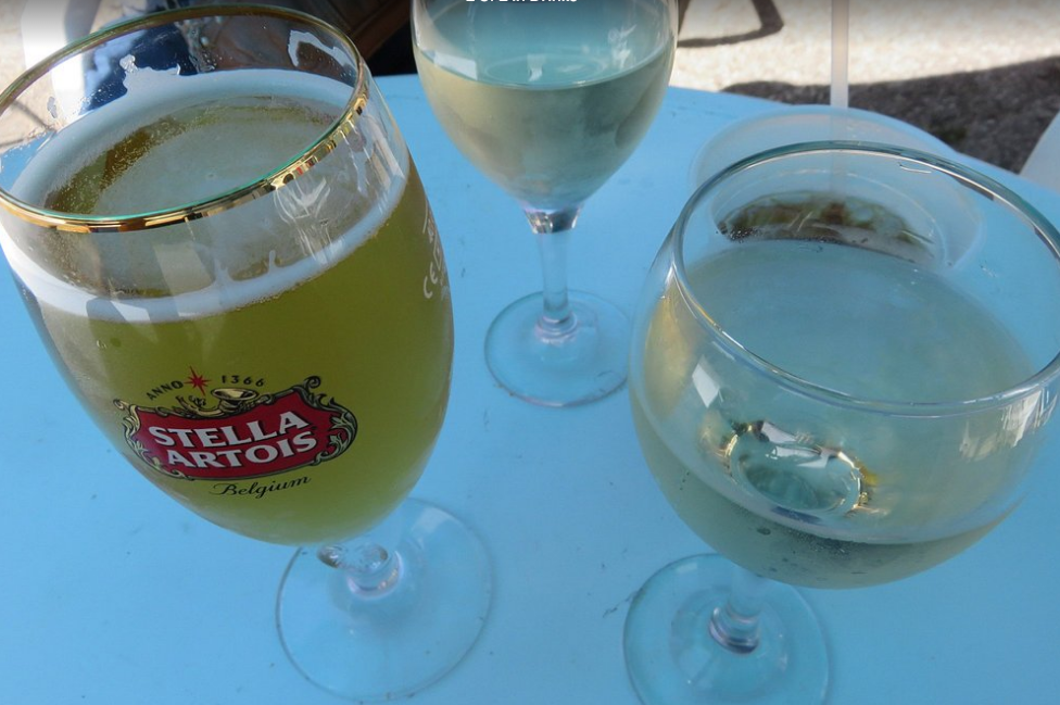 Two glasses of beer and two glasses of wine are on a table.
