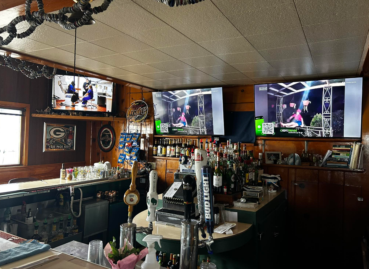 A bar with a lot of televisions on the wall.