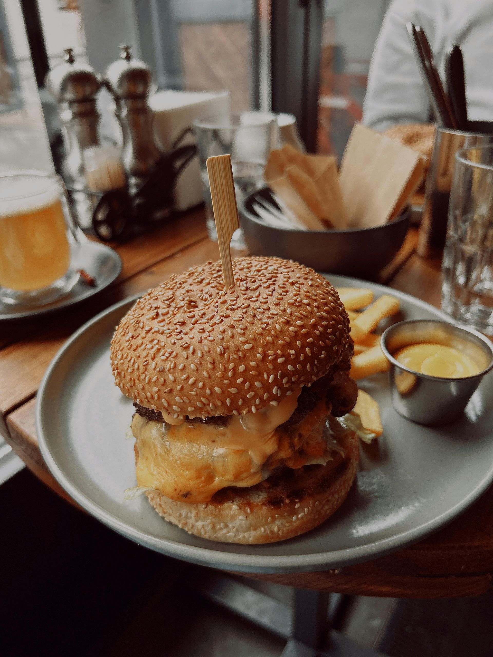 A hamburger and french fries are on a plate on a table.
