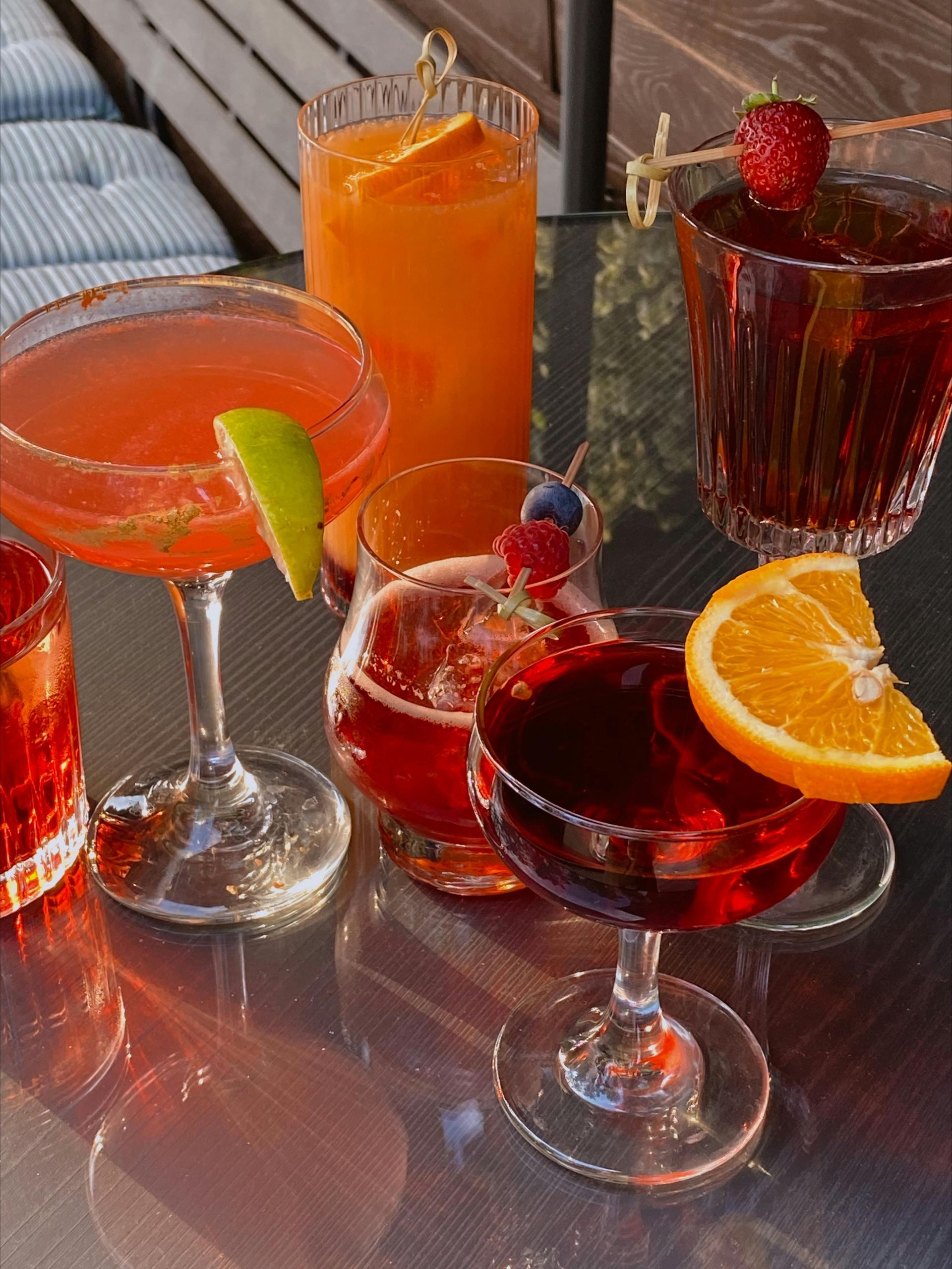 A table topped with a variety of drinks including a martini