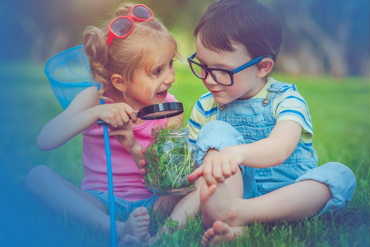 boy and girl outside sitting in grass