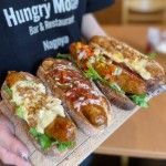 Hotdog Thumbnail - a picture of staff holding a tray of gourmet hotdogs