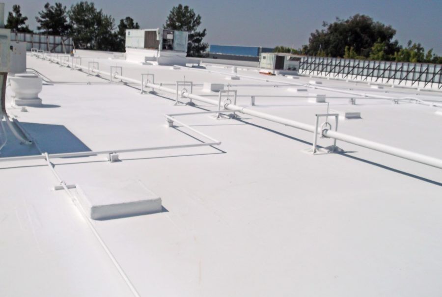 Two electricians working on an electrical panel outside a building. One holds a cable.
