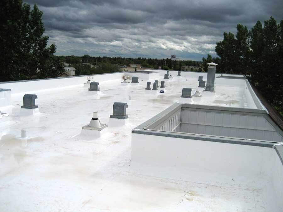 Two electricians working on an electrical panel outside a building. One holds a cable.