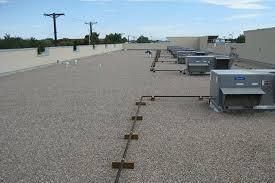 Trench dug in a grassy yard, leading to a house with black siding, and an electrical box.