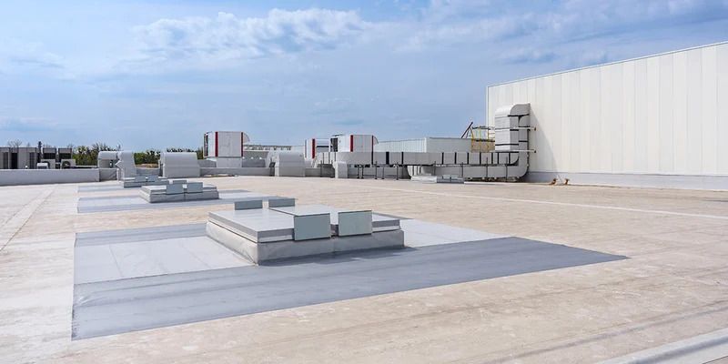 Two electricians working on an electrical panel outside a building. One holds a cable.