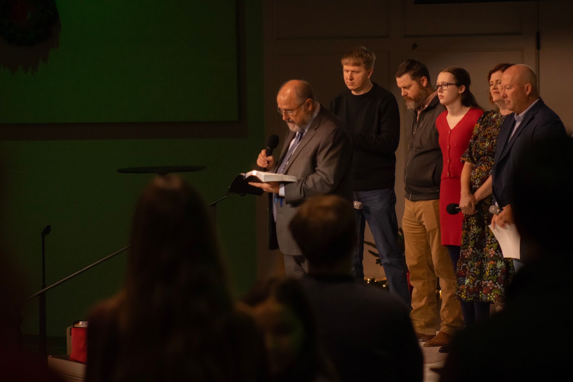 A group of people are standing in front of a green screen.