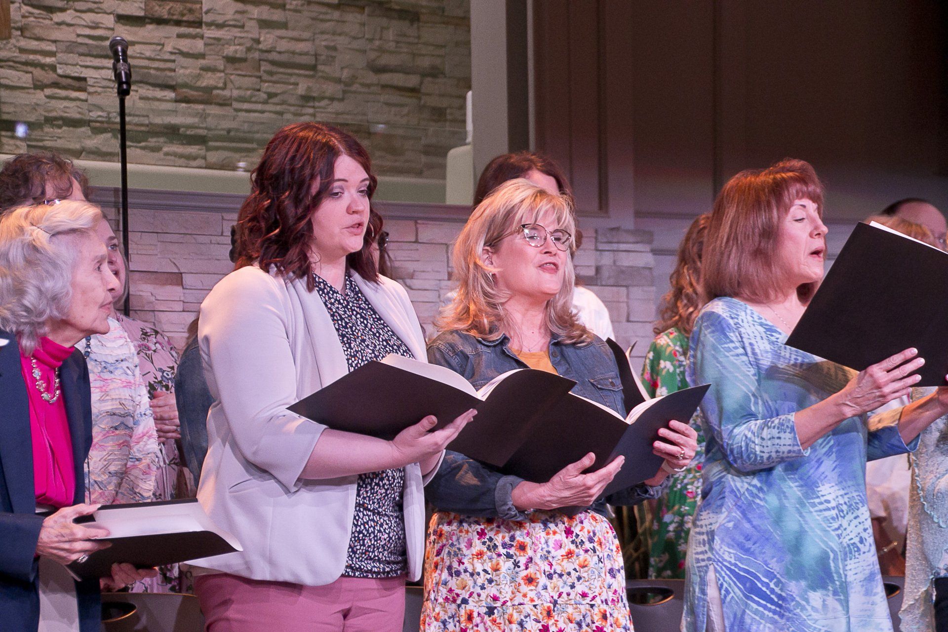 A group of women are singing together in a choir.