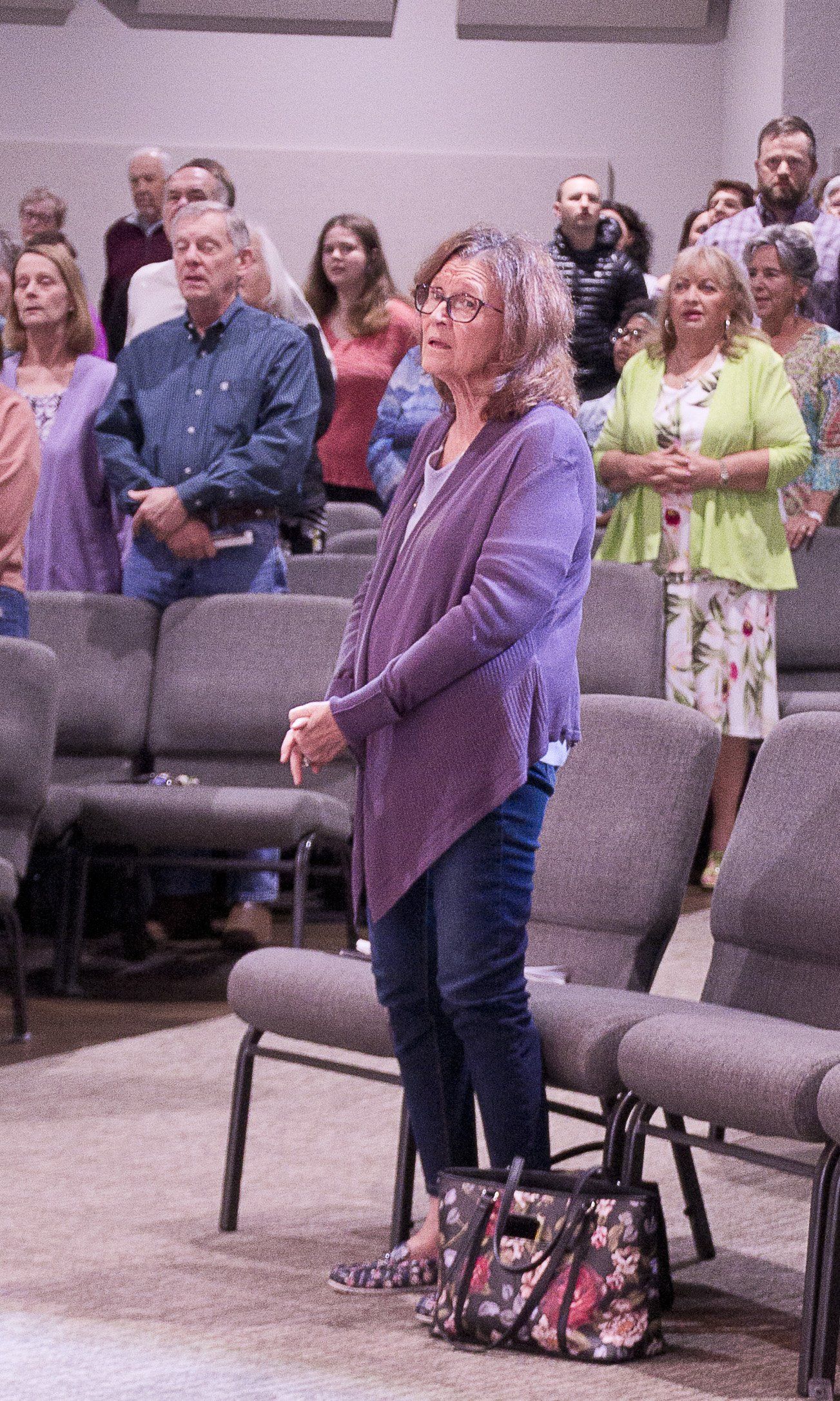 A woman is standing in front of a crowd of people in a church.