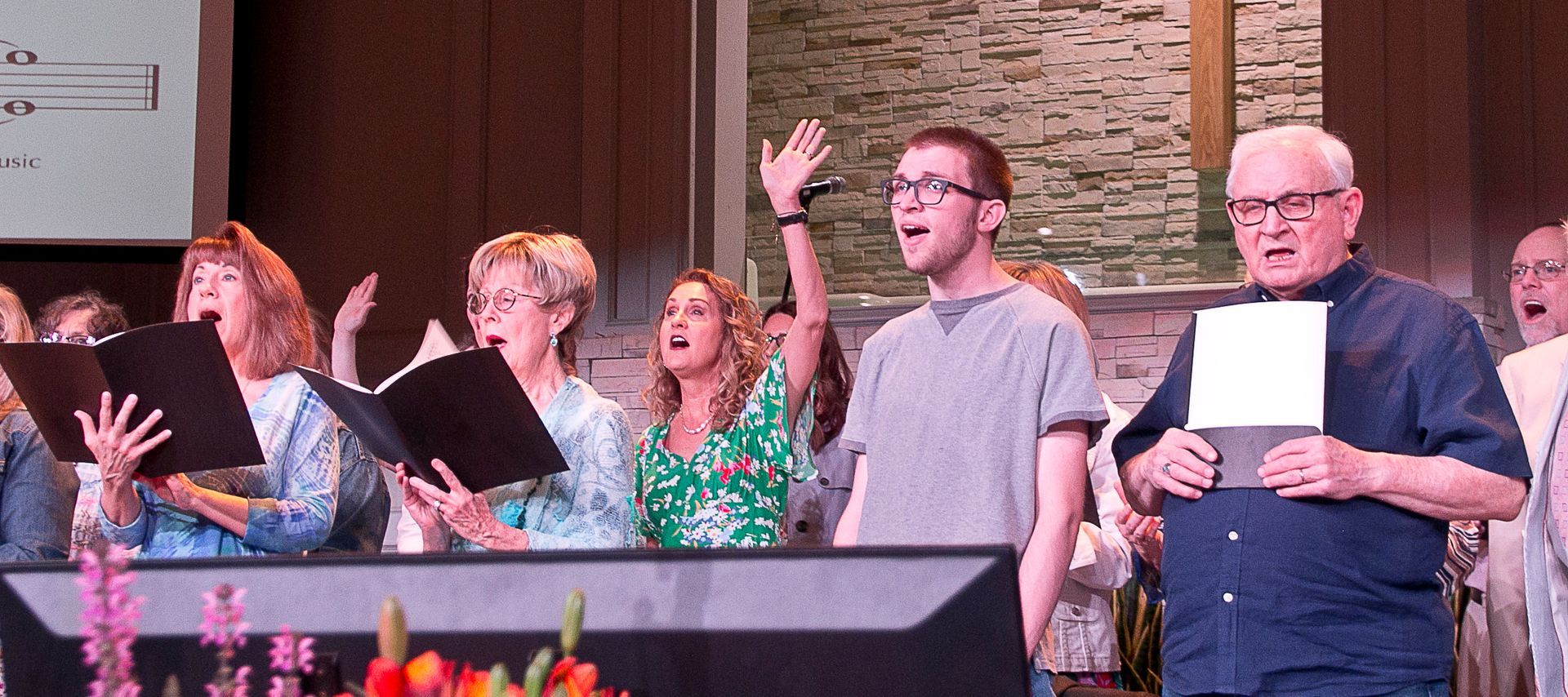 A group of people are singing in a church choir.