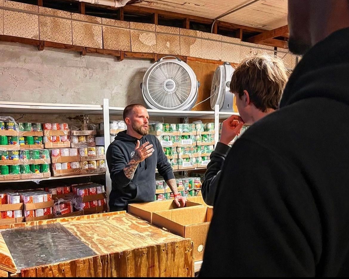 A man is talking to another man in a store.