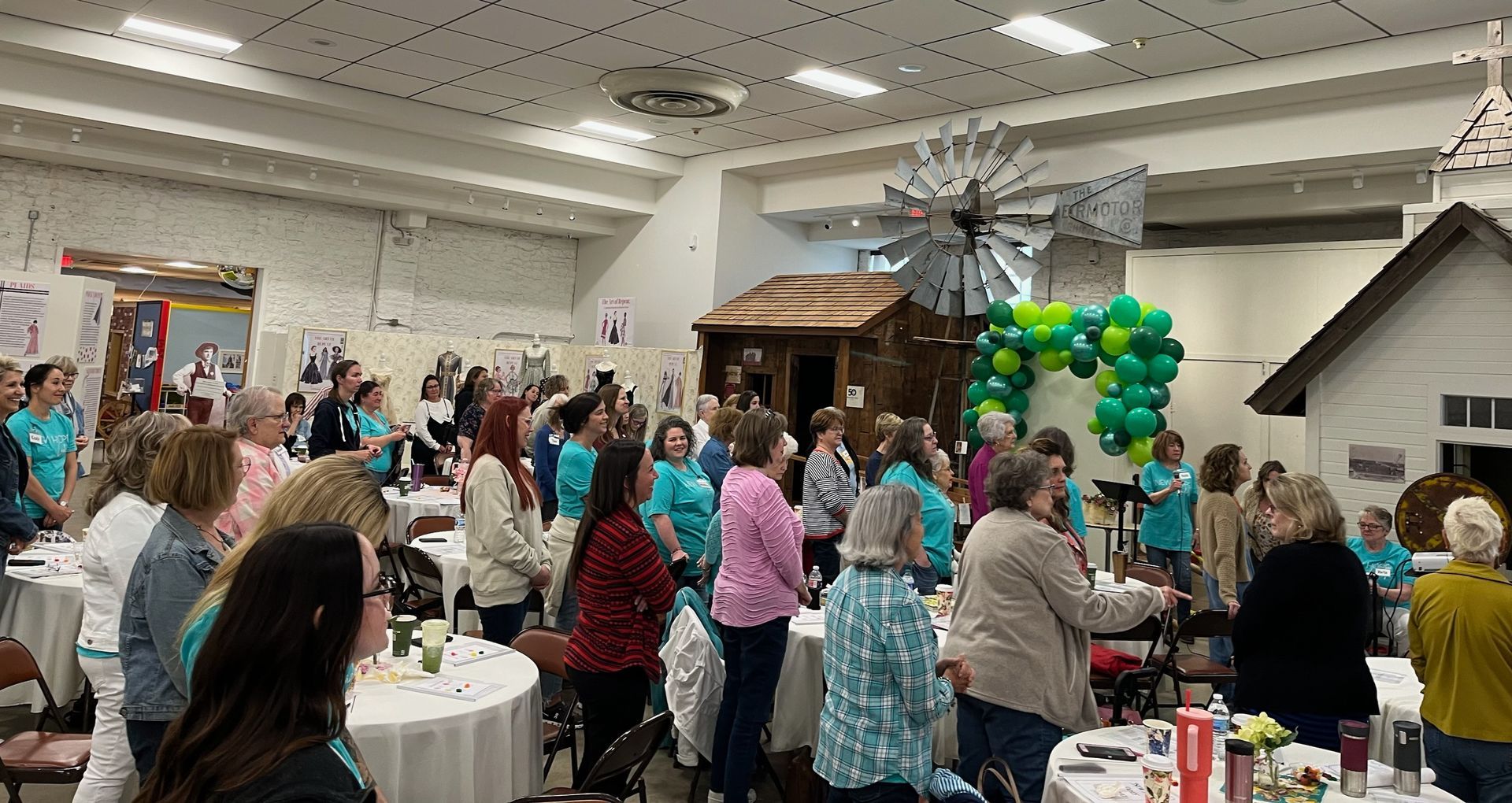 A large group of people are sitting at tables in a large room.