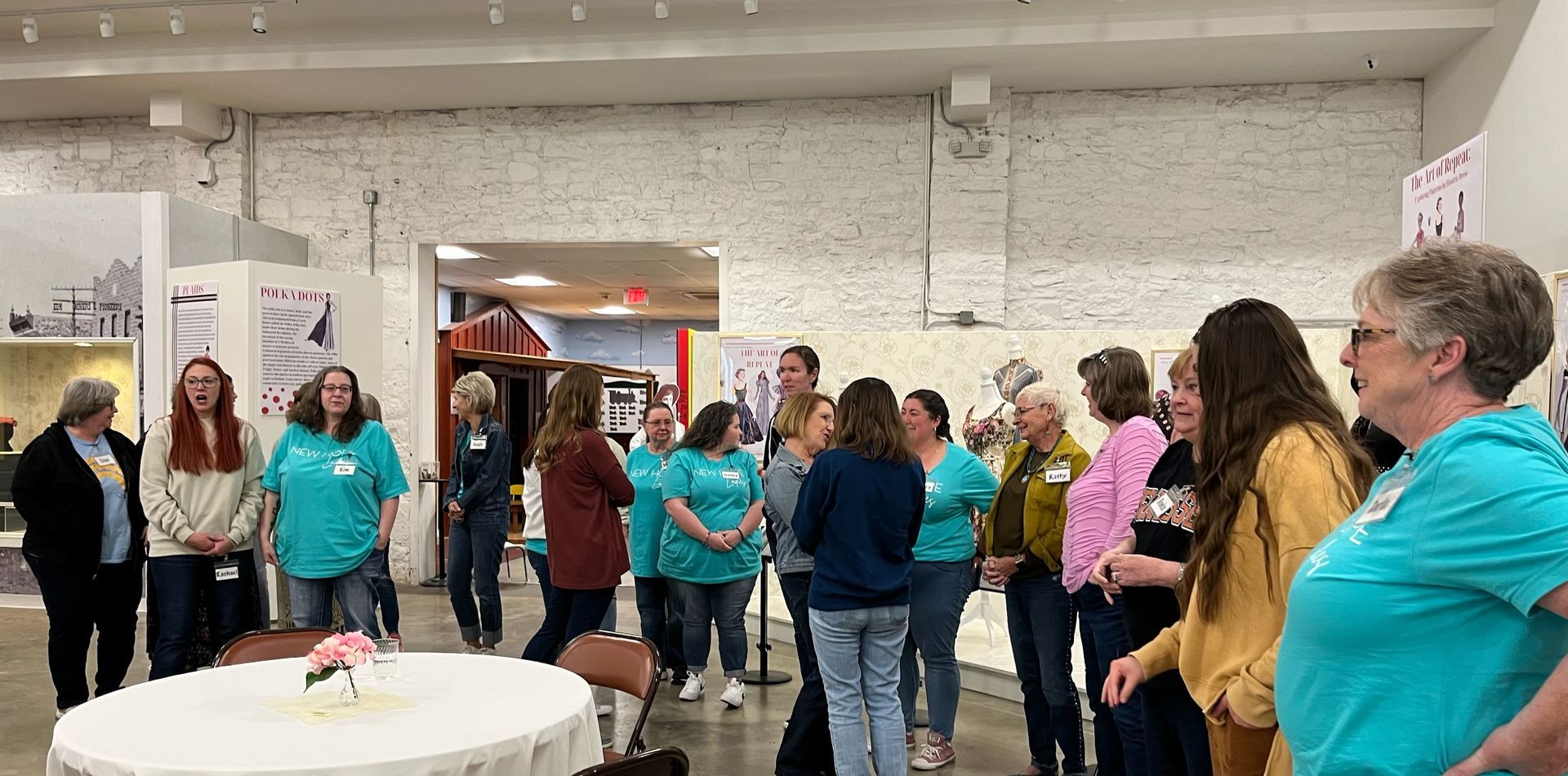 A group of people are standing around a table in a room.