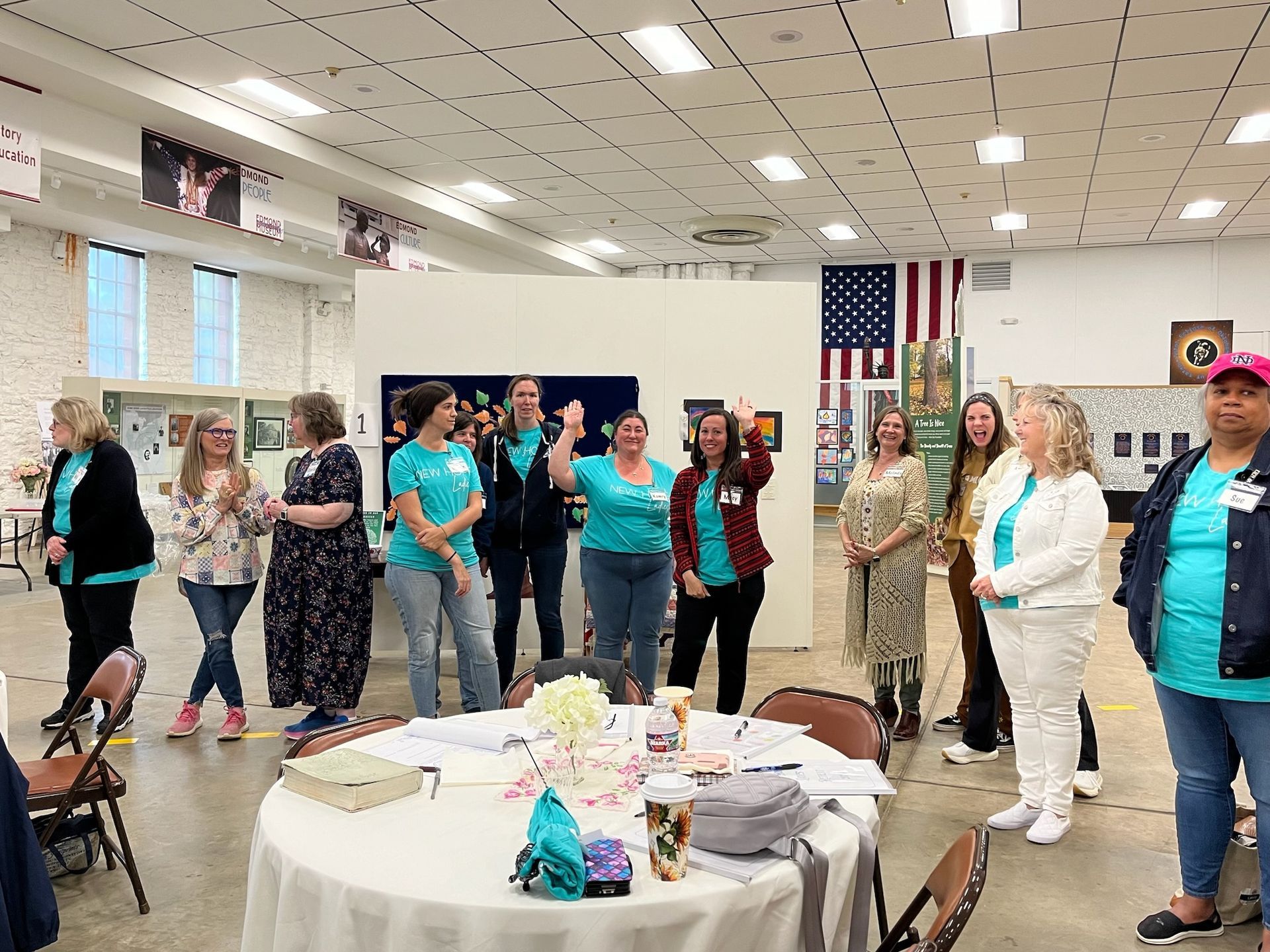 A group of women are standing around a table in a room.
