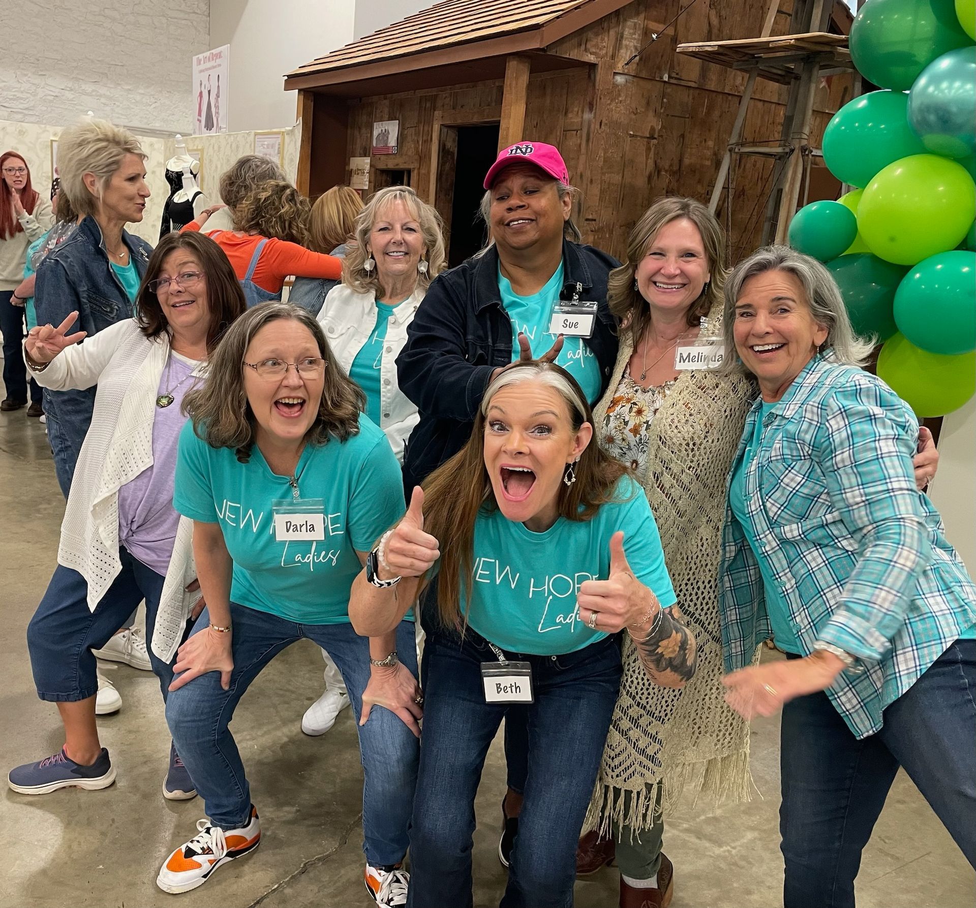 A group of people are posing for a picture with balloons in the background.