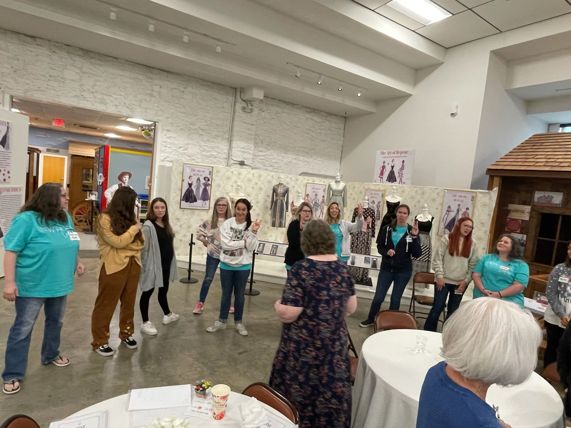 A group of women are standing around a table in a room.