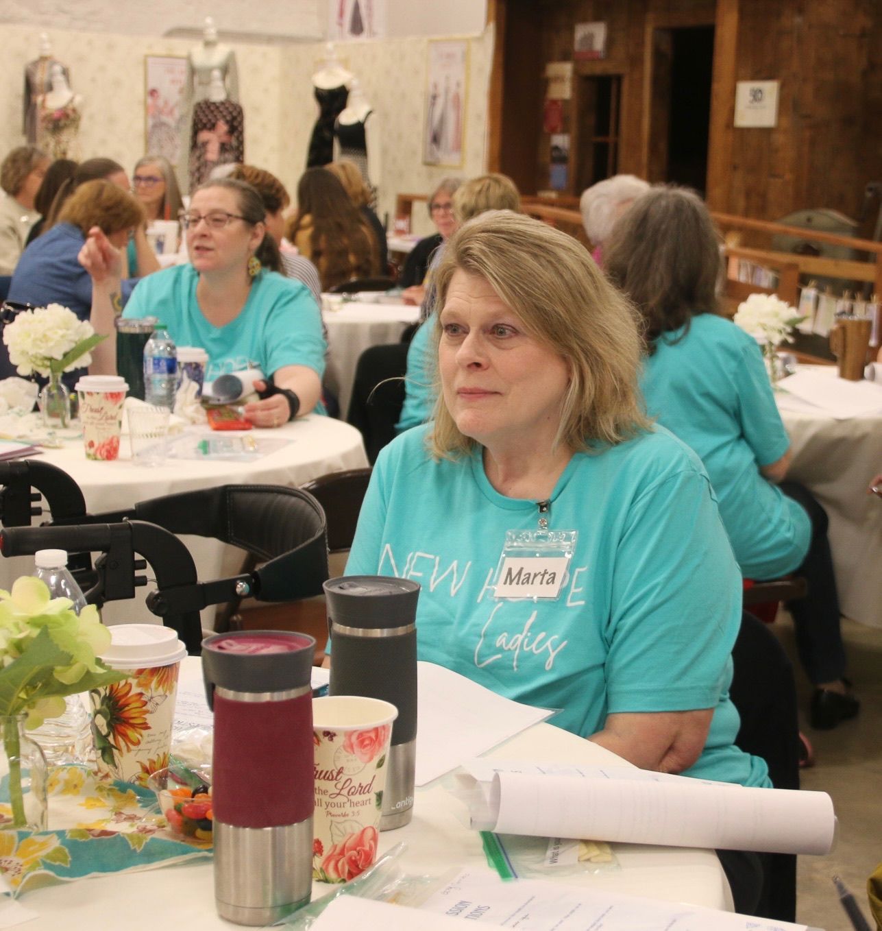 A woman in a new york today shirt sits at a table