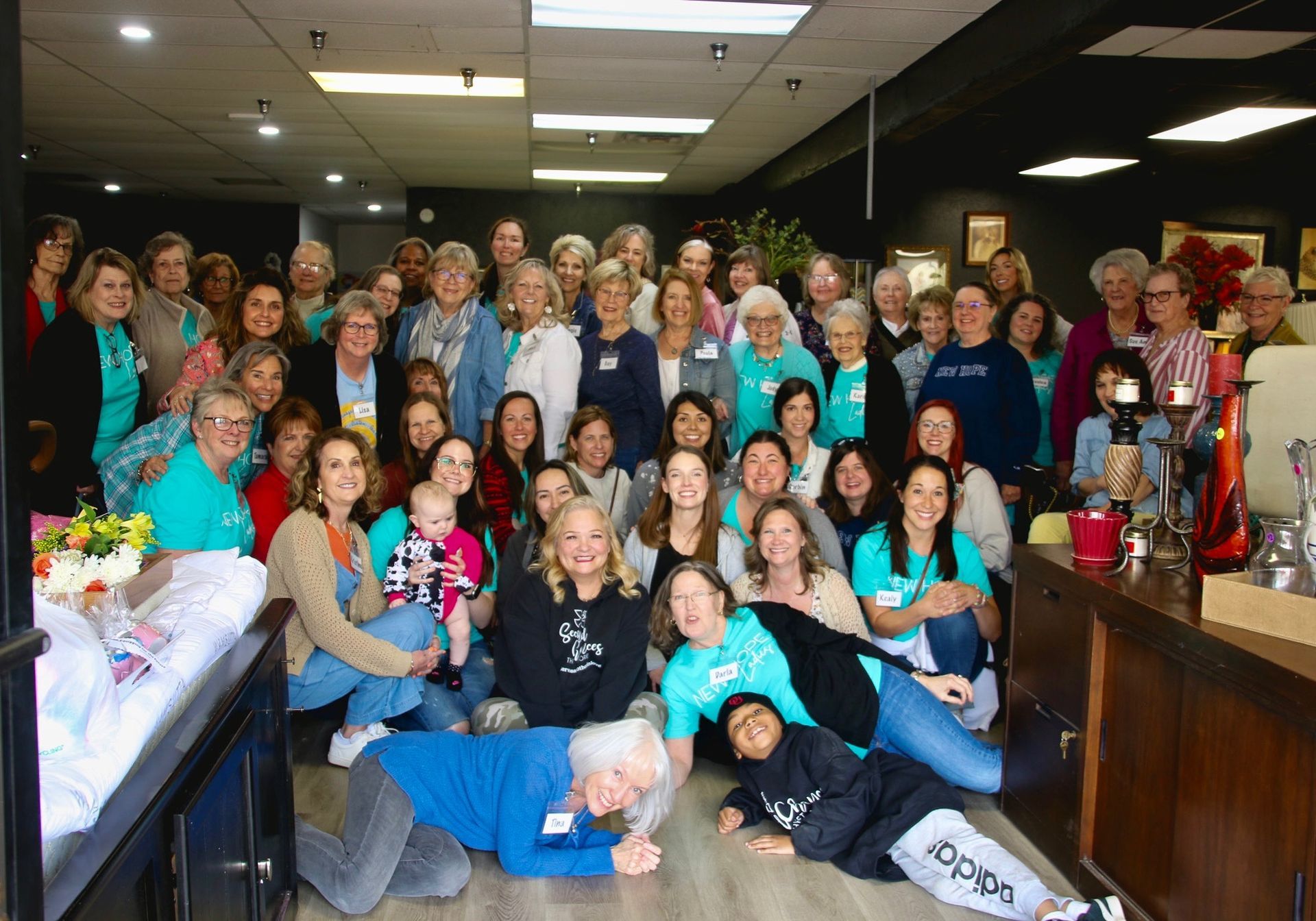 A large group of people are posing for a picture in a room.