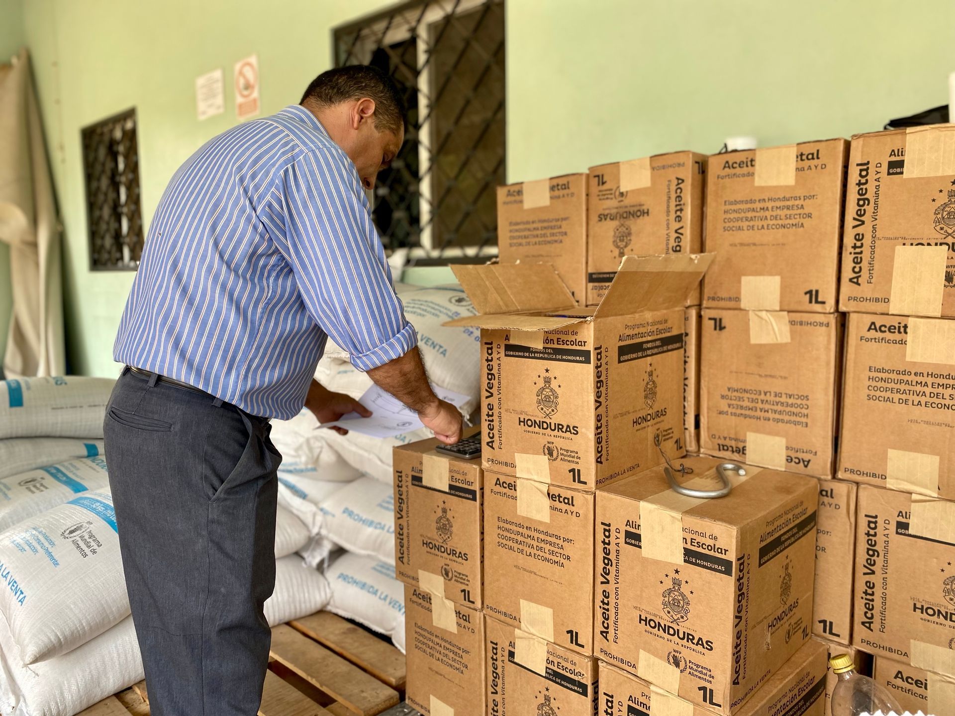 A man is standing in front of a stack of boxes that say essential