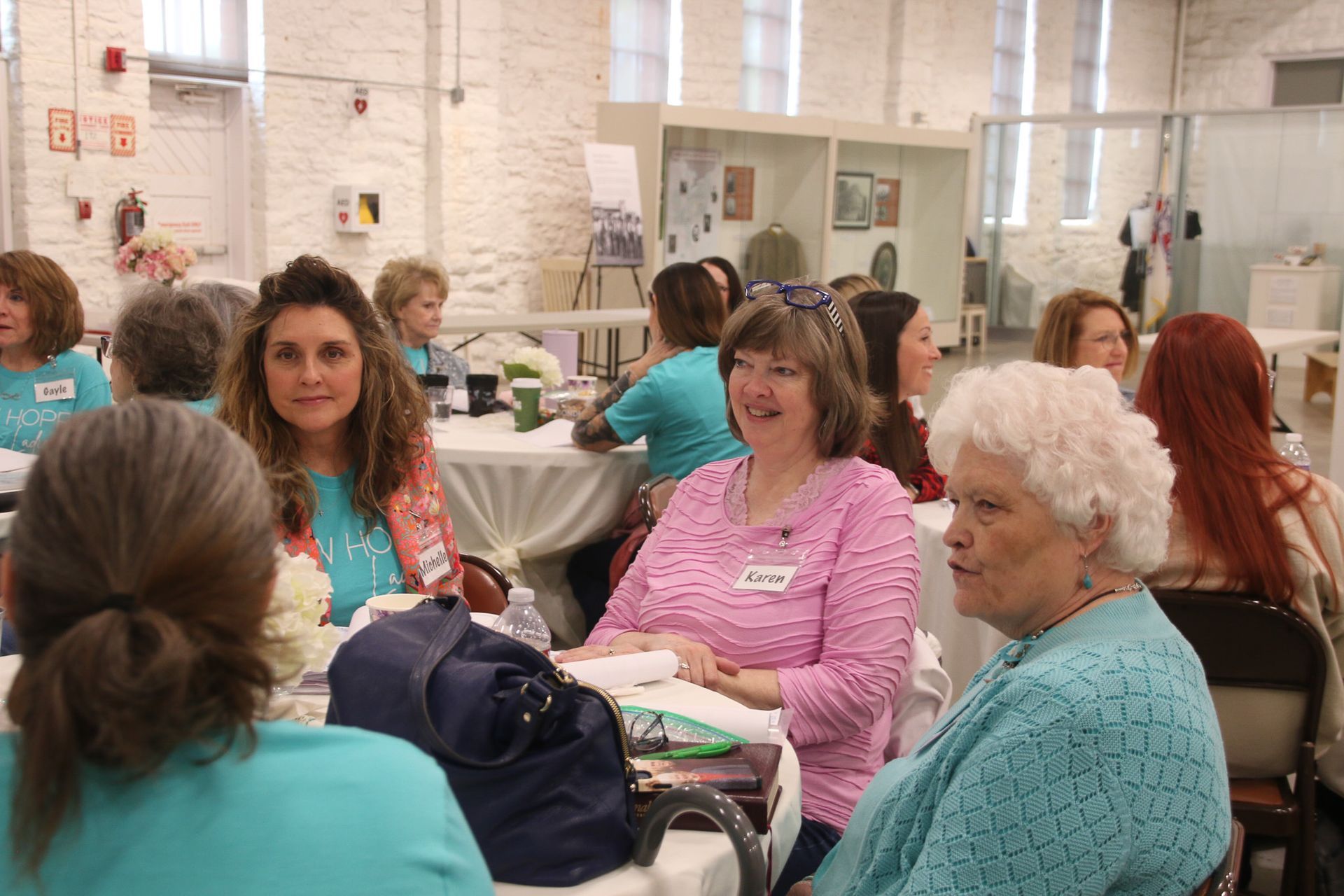 A group of women are sitting at tables in a room.