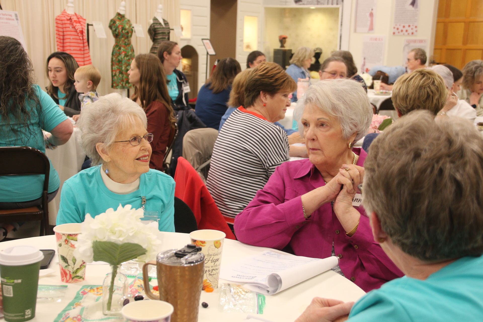 A group of people are sitting at a table talking to each other.
