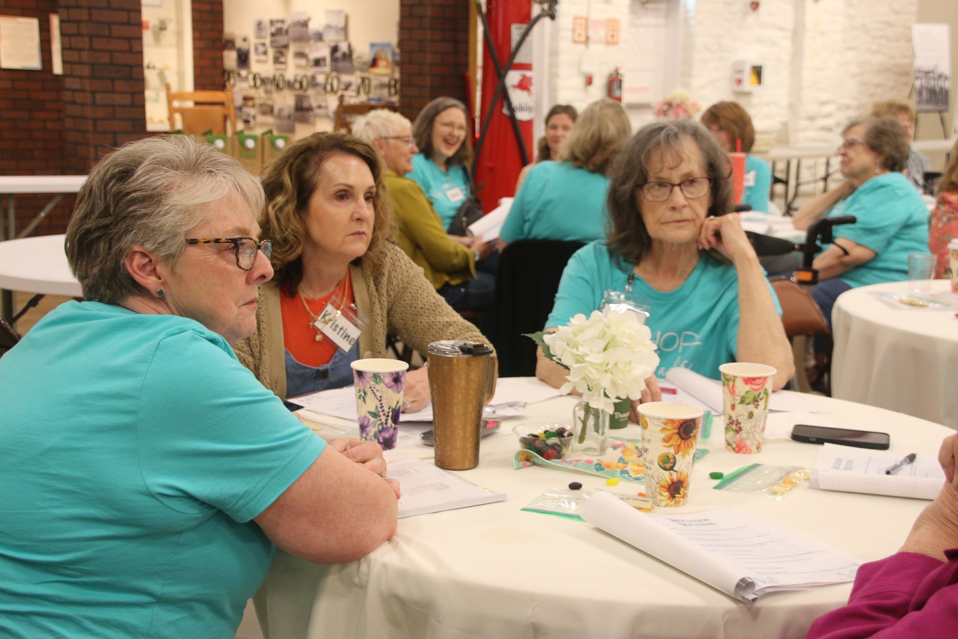 A group of women are sitting at tables in a room.