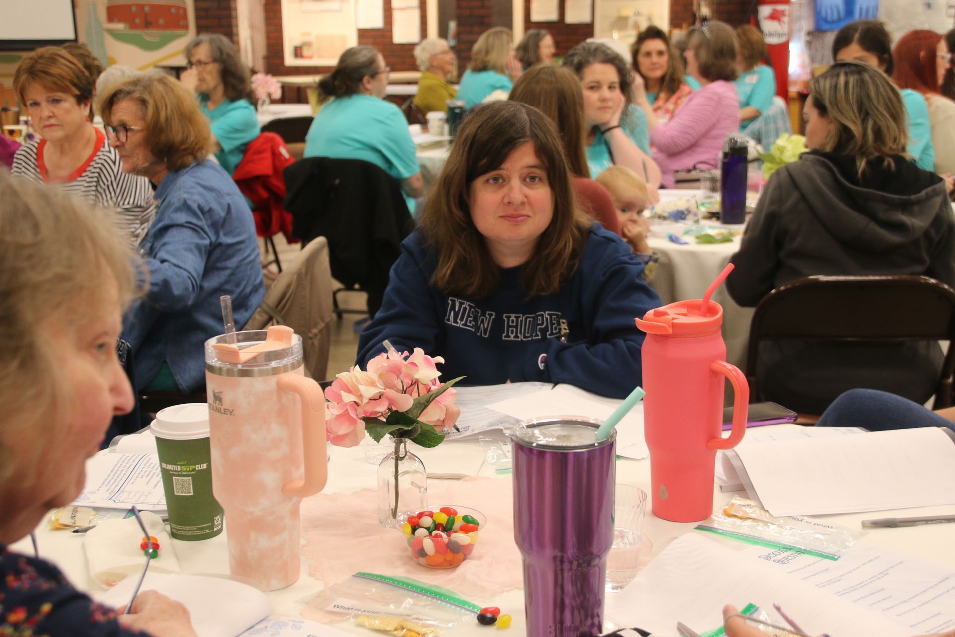 A group of women are sitting at tables in a room.