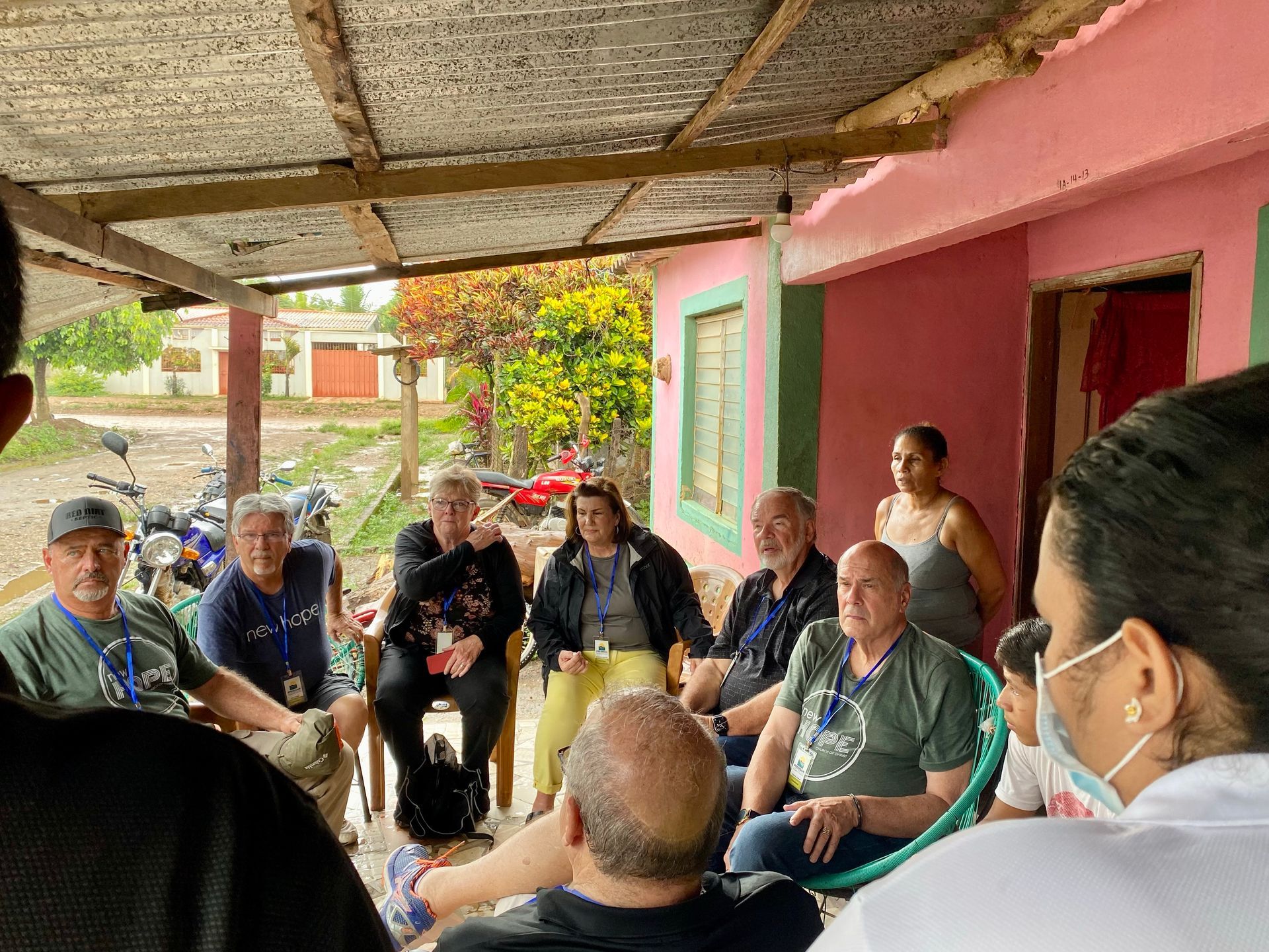 A group of people are sitting in a circle on a porch.