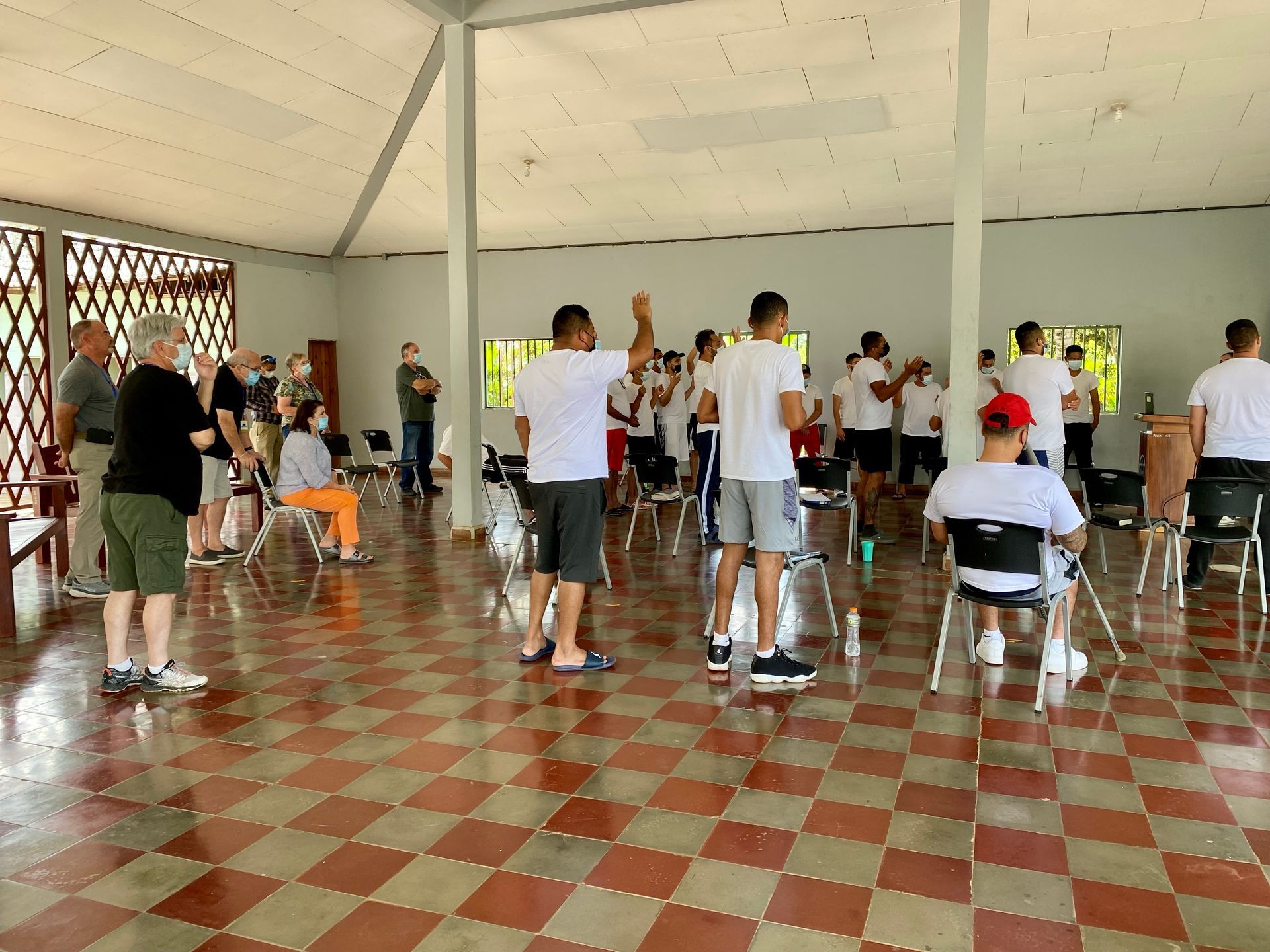 A group of people are standing in a room with a checkered floor.