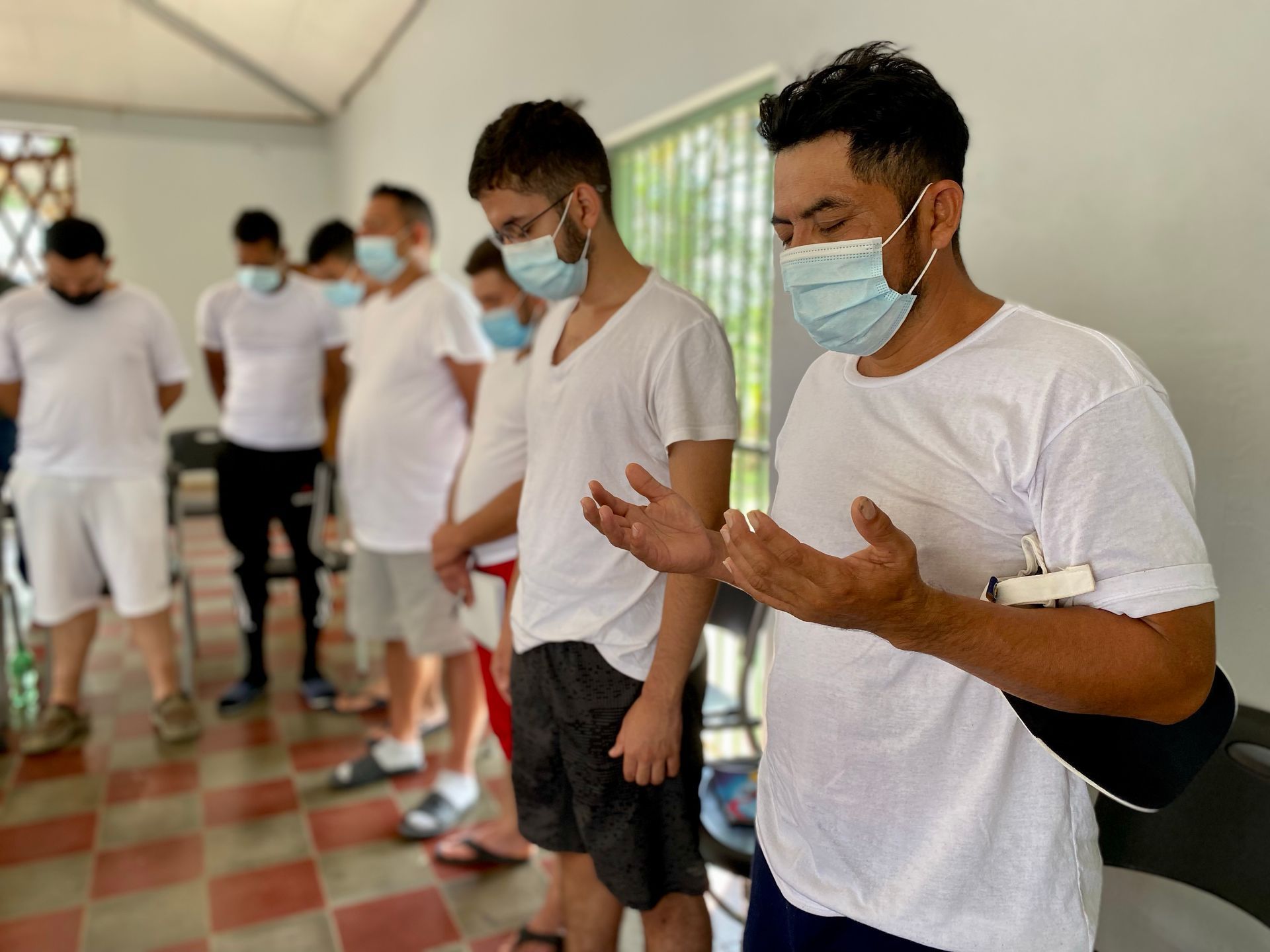 A group of men wearing face masks are standing in a room.