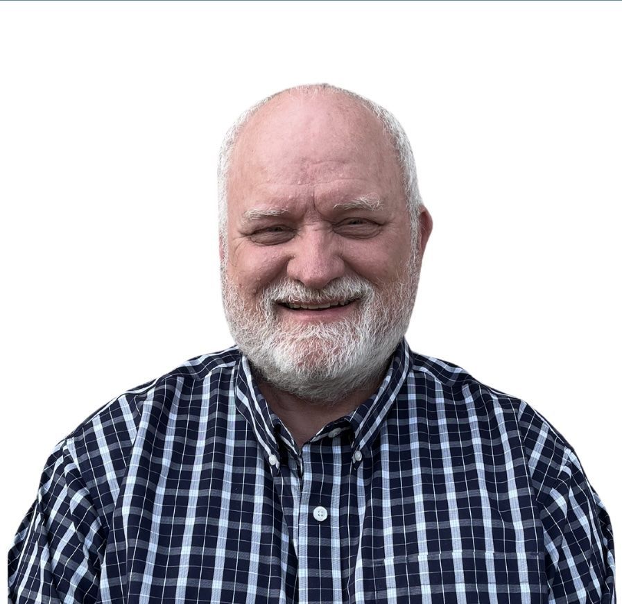 A man with glasses and a beard is smiling for the camera