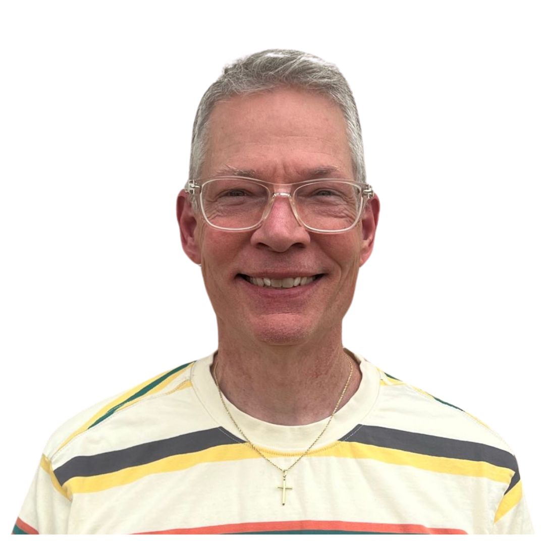 A man wearing glasses and a white sweater smiles for the camera