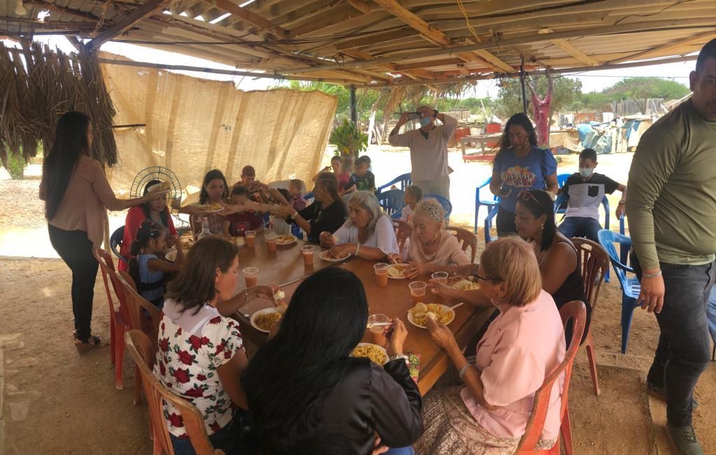 A group of people are sitting around a table eating food.