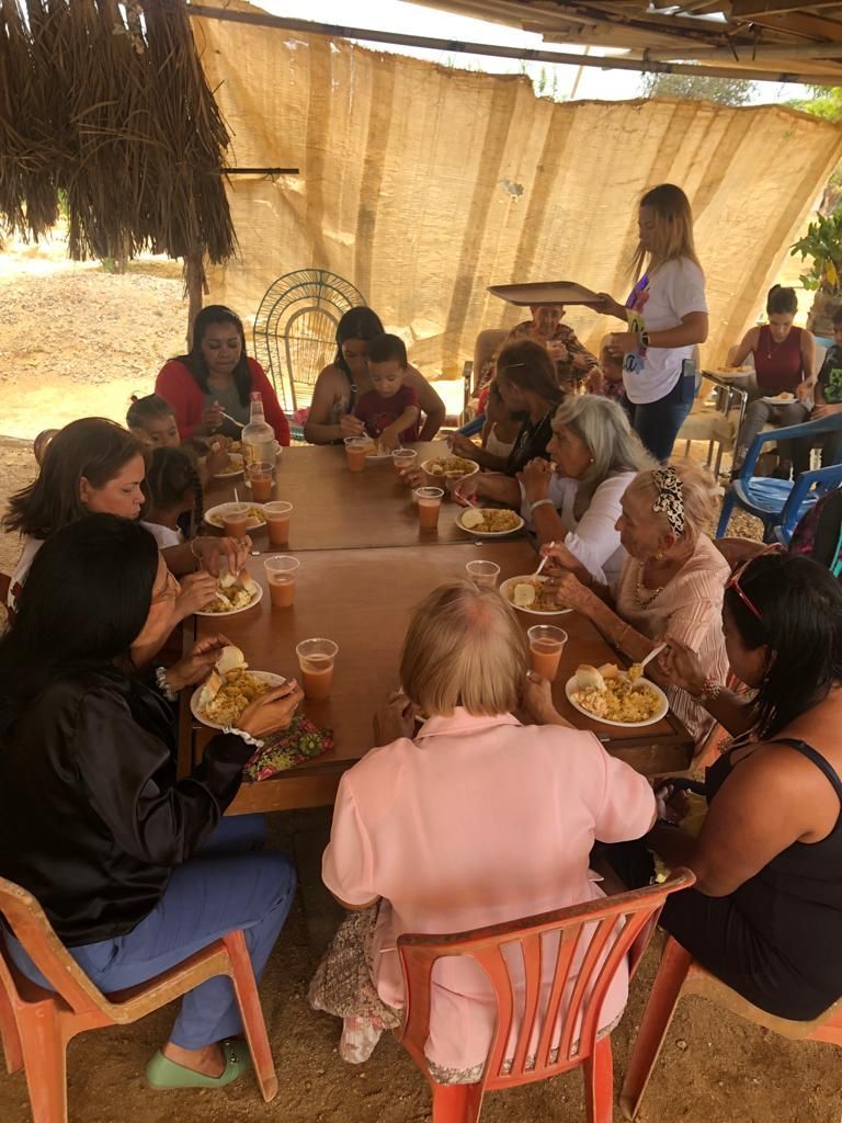 A group of people are sitting around a table eating food.