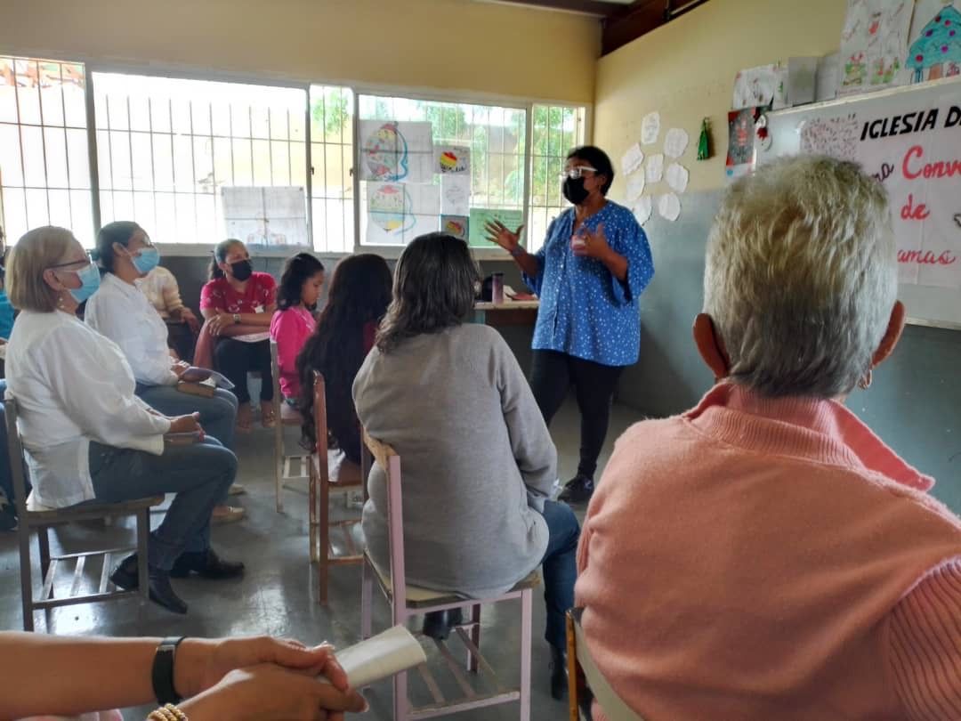 A woman is giving a presentation to a group of people sitting in chairs.