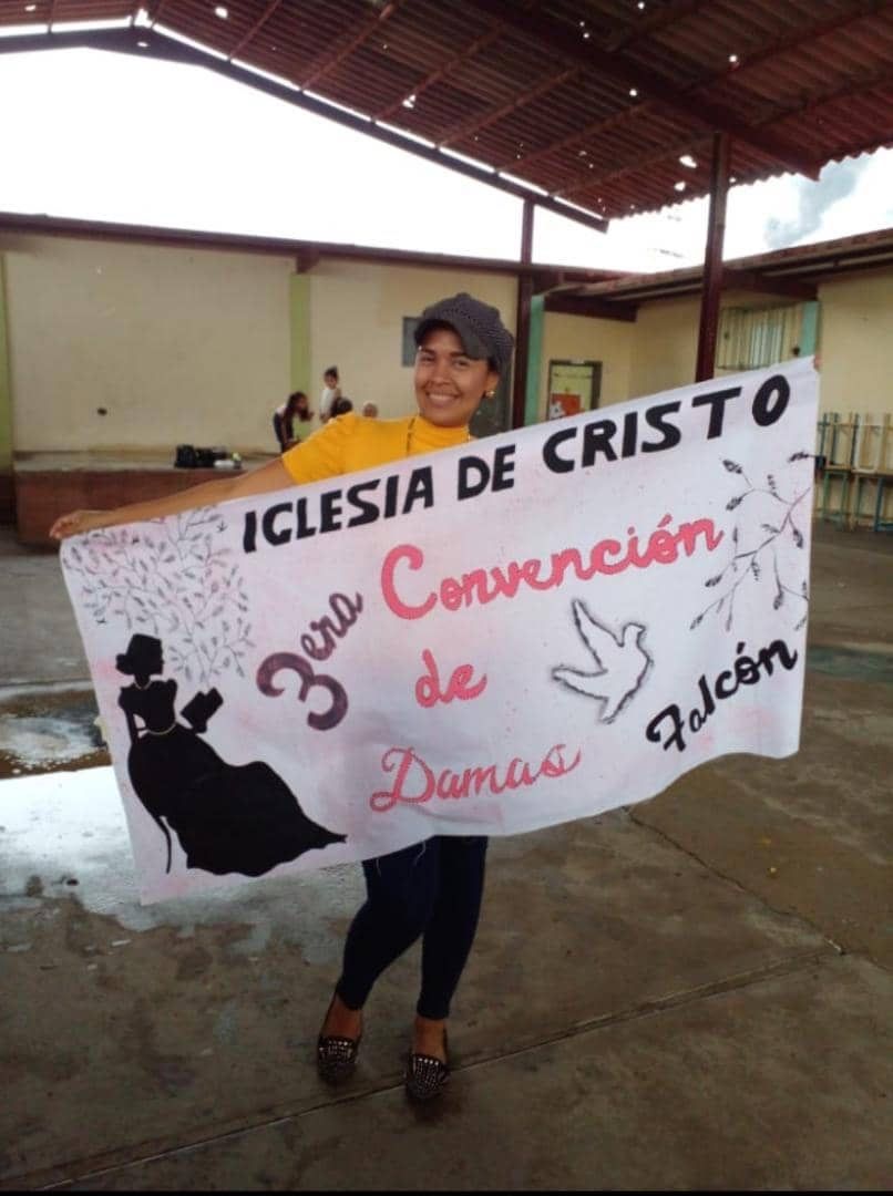 A person holding a sign that says iglesia de cristo